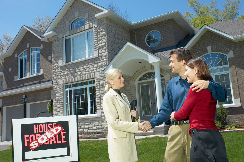 Couple shaking hands with real estate agent